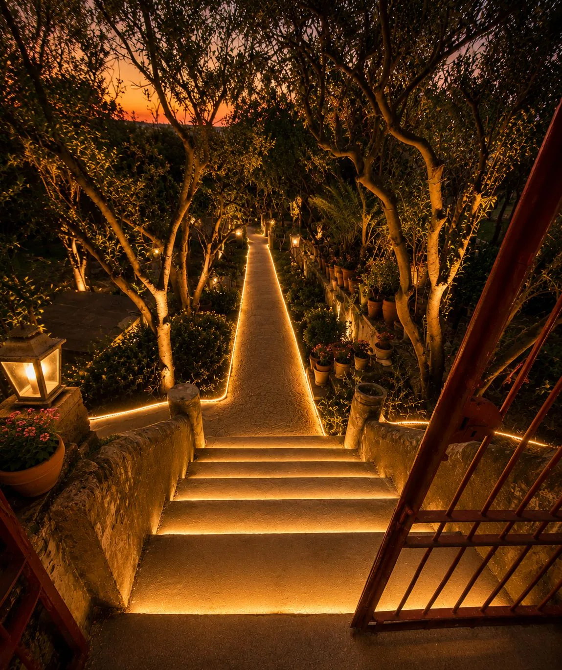 Scalinata illuminata che scende nel giardino segreto della bubble room di Capua